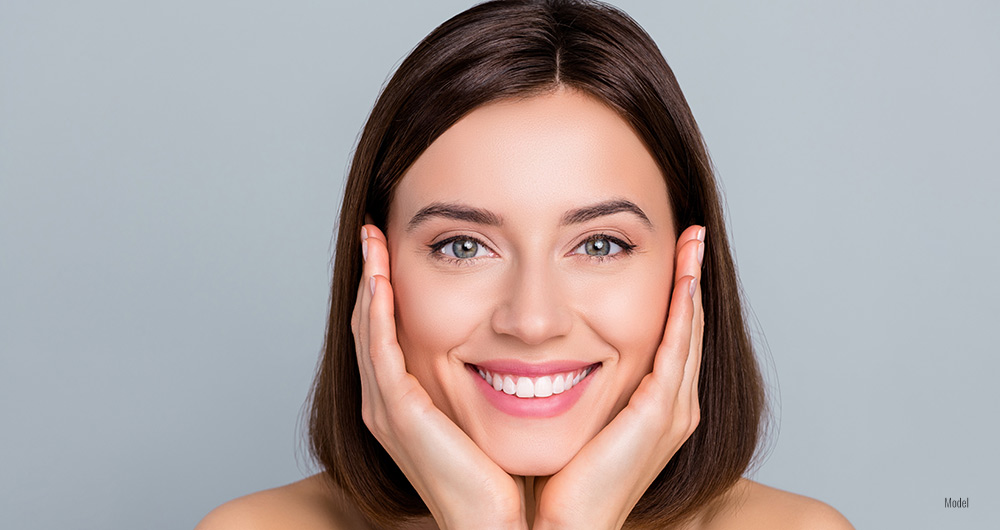 close up of woman smiling and holding her cheek