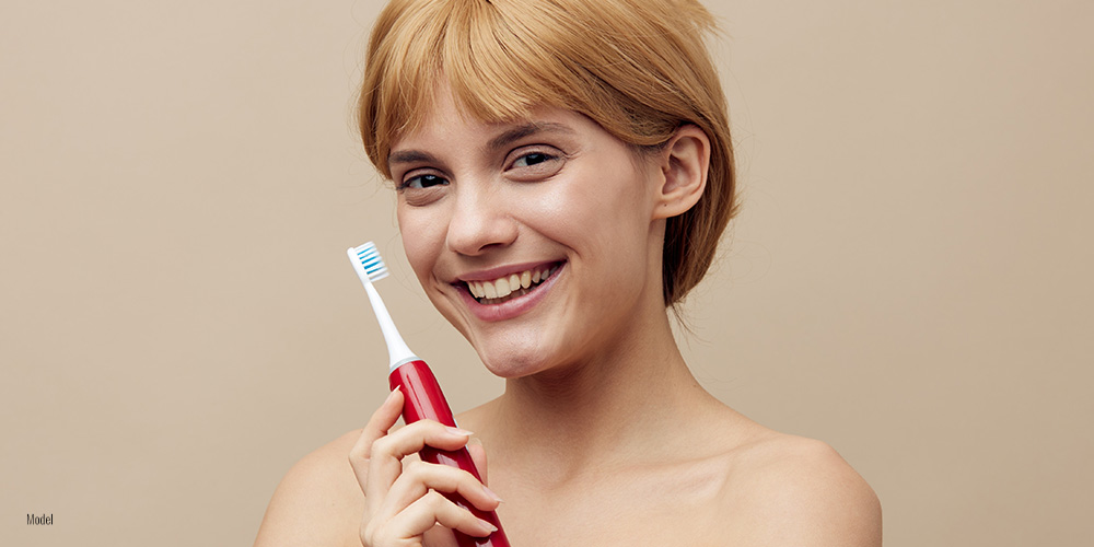 Female holding electric tooth brush